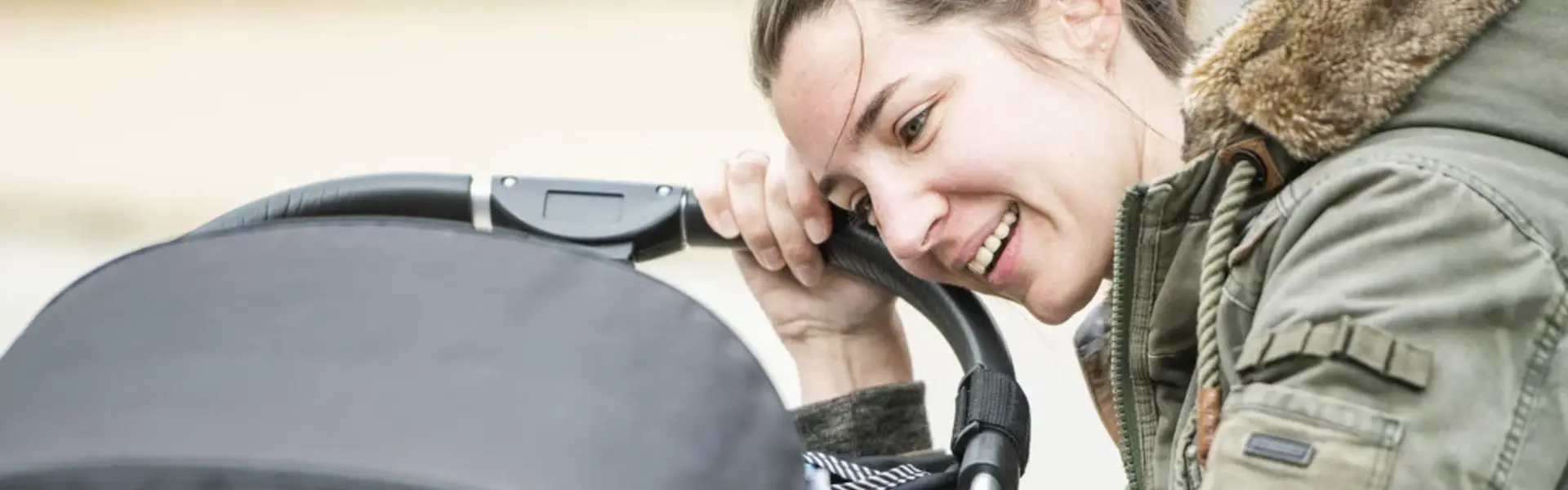 Mutter über Kinderwagen gebeugt